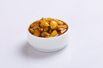 Fermented garlic cloves in a jar of honey, a rich source of probiotics, over a rustic wood background table. Selective focus with blurred background and foreground.
