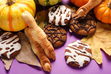 Halloween cookies with fallen leaves and pumpkins on violet background