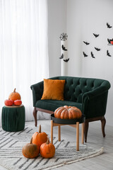 Interior of living room decorated for Halloween with green sofa and pumpkins