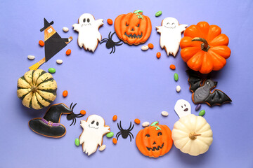 Frame made of Halloween cookies, candies and decor on violet background