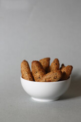 small French baguettes in a white bowl against gray background