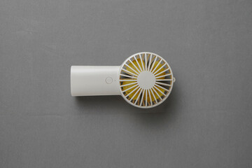 The handheld fan is white. Portable mini fan. Practically carried anywhere.