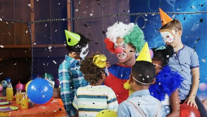 Animation of confetti over clown showing tricks to multiracial friends at birthday party - Powered by Adobe