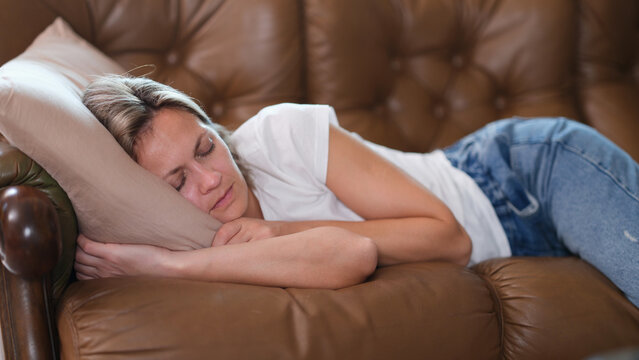 Sleeping lazy woman lies on couch during day