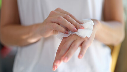 Right hand wipes left hand with piece of damp cloth closeup