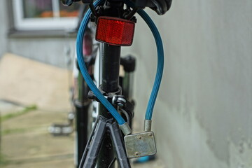 old iron reliable bicycle closed bicycle theft protection lock hanging on the saddle of a black modern bicycle in the street