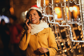 Black Woman Using Smartphone In The City At Christmas Time