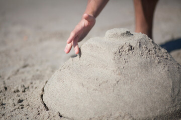 a man builds a sand castle. Castle in the form of a tank