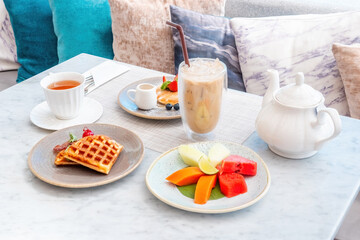 Sweet breakfast in cafe with belgian waffles, pancakes with berries