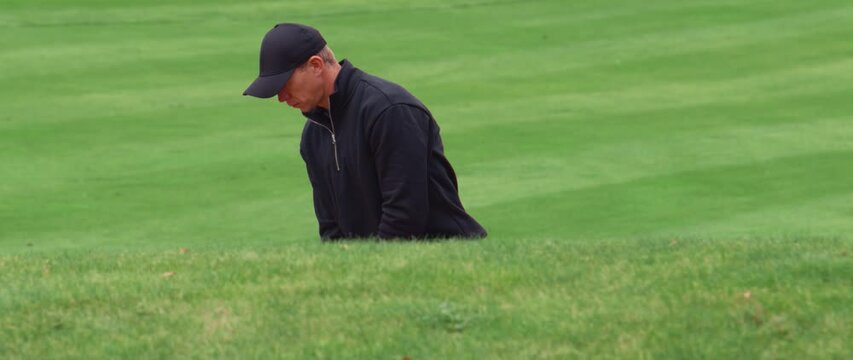 MED Caucasian male playing a bunker shot during a golf game. Super slow motion shot