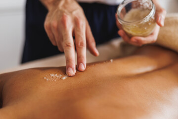 Woman Enjoying Peeling Massage With Salt In Spa Centre
