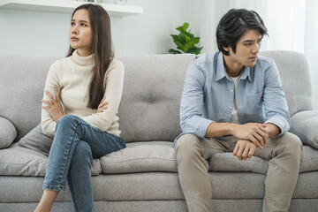 Family problems, Asian women cover her face and sit separately from husband feel disappointed after quarrels at home. - obrazy, fototapety, plakaty