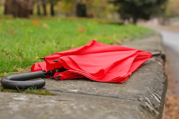 Stylish bright umbrella on parapet outdoors