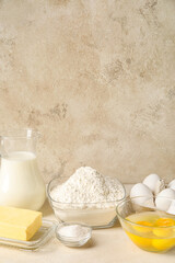 Different ingredients for baking on table against light background