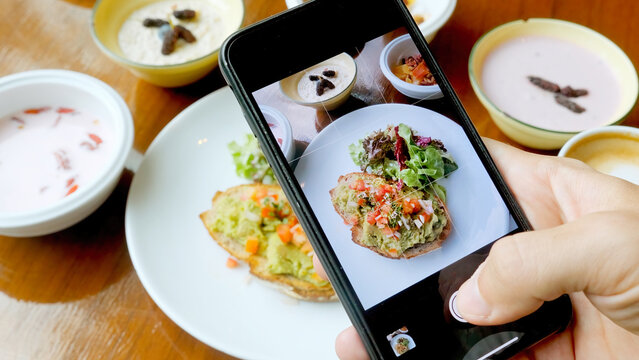 Male person take photos of healthy breakfast food by modern smartphone