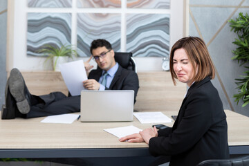 Frustrated female office worker crying because of her angry boss fired her and pointing to the door	