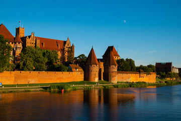 Naklejka na ściany i meble Marienburg Castle the largest medieval brick castle in the world in the city of Malbork at sunset