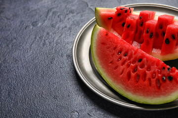 Plate with slices of watermelon on dark background, closeup