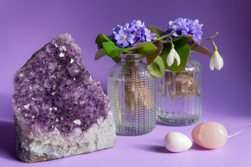 Two yoni eggs - rose quartz stone and white jade stone on violet background