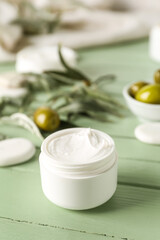 Fototapeta na wymiar Jar of olive cream on color wooden background