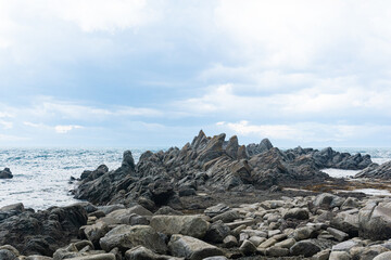sharp jagged basalt rocks on the sea coast, Cape Stolbchaty on Kunashir Island