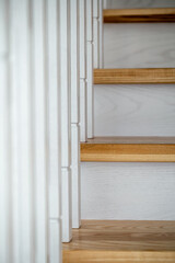 Wooden white staircase in the interior of the house, detail.
