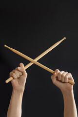 drumsticks in hands on a black background.