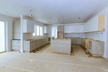 The installation of white kitchen cabinets in newly constructed house
