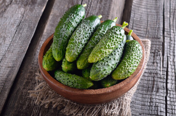 Fresh cucumbers in wooden bowl