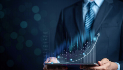 Businessman using tablet to analyze sales data trading and showing a growing virtual screen of statistics, graph and chart with arrow up. Stock market business growth, planing and strategy concept.