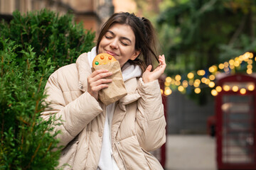 Attractive young woman with a beautiful gingerbread on a walk.