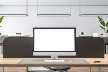 Front view on blank white monitor screen with place for your logo or text on wooden workspace table in minimalistic style office with black partition on light wall background. 3D rendering, mockup