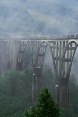 tall bridge over the river covered with fog