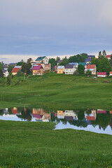 reflection of a little village on the surface of a lake
