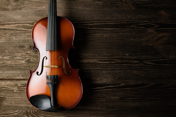 Fototapeta na wymiar Classic violin on wooden table background, top view.