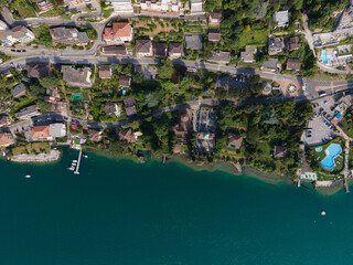 Fototapeta na wymiar Campione d'Italia coast line during summer time with the Lugano lake view and swimming pools and boats and roads and houses