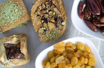 Macro Image of Delicious Lebanese Desserts with Yellow Raisins and Walnut Bowls on Cloth