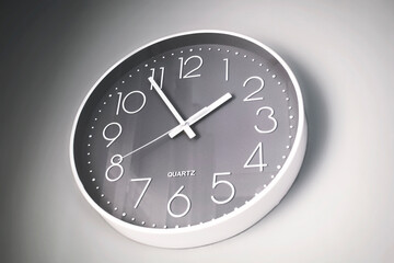 Minimalist clock hanging on a grey wall