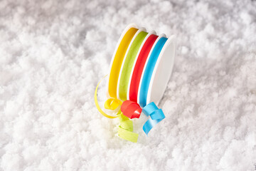 Multicolored gift ribbon on snow.