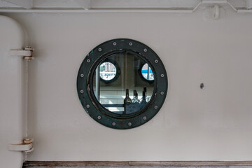Drunkenness on ship during voyage. Alcohol bottles inside cabin visible through the porthole