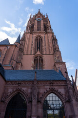 Fototapeta na wymiar Bell tower of the Frankfurt Cathedral seen from the base, with the day with many clouds.