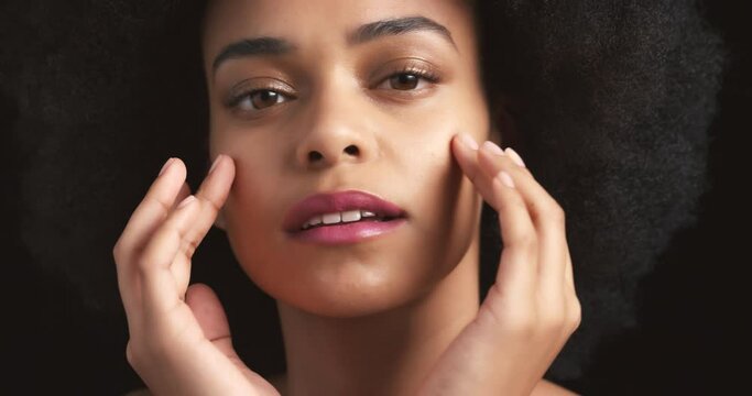 Black woman, afro and face skincare on a studio background with hand touching glowing skin. Beauty model zoom portrait with fashion hair, cosmetics makeup and health wellness in self care dermatology