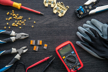 Different electrical tools on wooden background, flat lay.