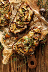 Sourdough bread toasts with mushrooms, mozzarella cheese and thyme on a wooden table, top view - obrazy, fototapety, plakaty
