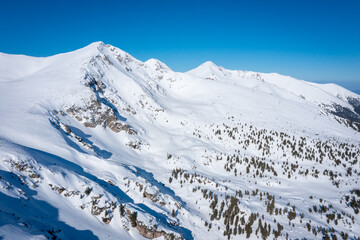 Peaks mountain Pirin covered in snow in Winter sunny day. Bansko, Bulgaria