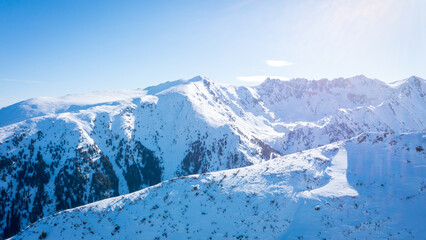 Fototapeta na wymiar Peaks mountain Pirin covered in snow in Winter sunny day. Bansko, Bulgaria