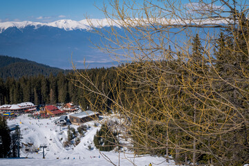 Winter landscape with panorama of Bansko above the clouds. Famous ski resort in Bulgaria. View of the ski slopes and the Pirin Mountains