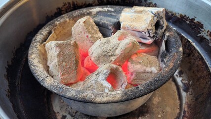 Lighting charcoal in the stove preparing for food