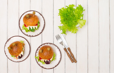 Halloween monster burgers for halloween on white wooden background top view. Fun food art for kids.