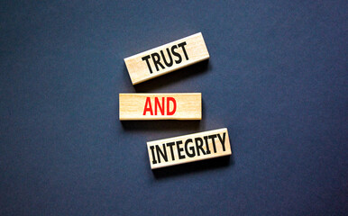 Trust and integrity symbol. Concept words Trust and integrity on wooden blocks. Beautiful grey table grey background. Business, psychological and trust and integrity concept. Copy space.